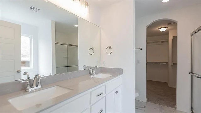 bathroom featuring vanity and an enclosed shower