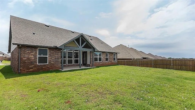 rear view of house with a patio area and a lawn