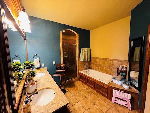 bathroom featuring tile patterned flooring, vanity, and shower with separate bathtub