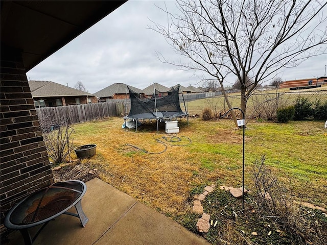 view of yard featuring a trampoline and a patio