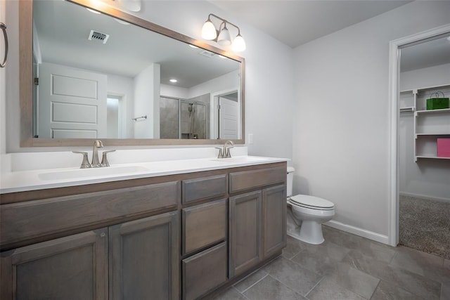 bathroom featuring vanity, toilet, and a shower with door