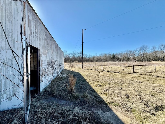 view of yard featuring a rural view and an outbuilding