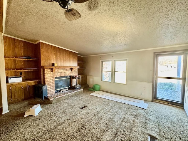 unfurnished living room featuring ornamental molding, plenty of natural light, carpet flooring, and a textured ceiling