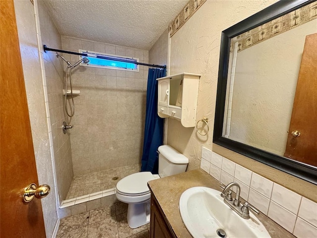 bathroom featuring vanity, curtained shower, toilet, and a textured ceiling