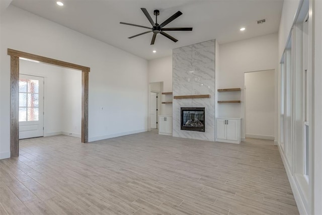 unfurnished living room with a fireplace, light hardwood / wood-style floors, and ceiling fan