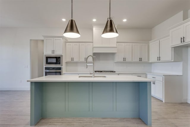 kitchen with white cabinetry, oven, and decorative light fixtures