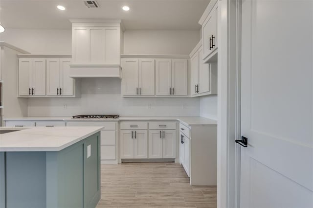 kitchen with white cabinetry, gas cooktop, and tasteful backsplash