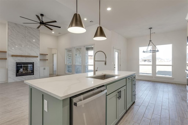 kitchen featuring pendant lighting, sink, dishwasher, and a center island with sink