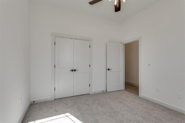 unfurnished bedroom with light colored carpet, ceiling fan, and a closet