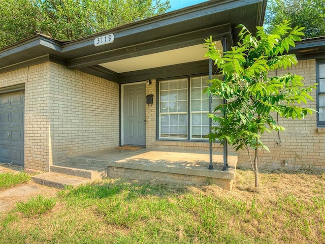 doorway to property with a garage and a porch