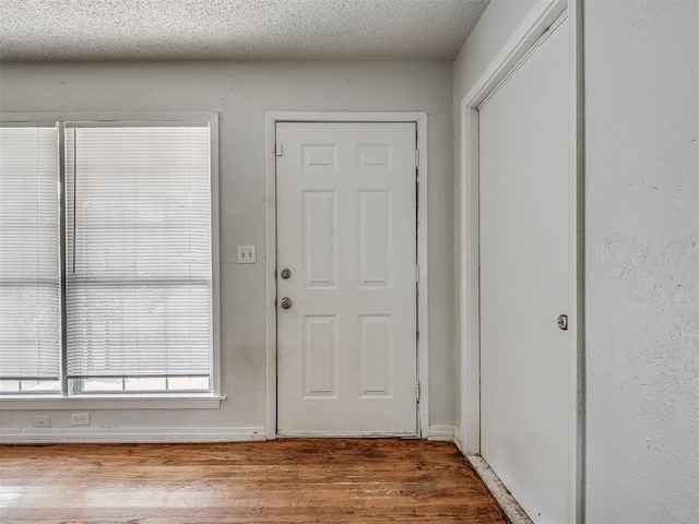 foyer entrance featuring light hardwood / wood-style flooring and a textured ceiling