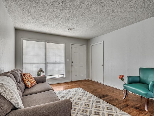 living room with wood-type flooring and a textured ceiling