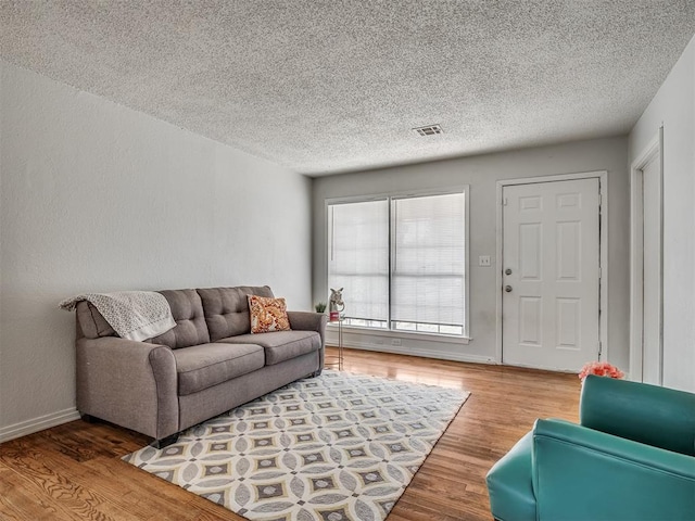 living room with hardwood / wood-style floors and a textured ceiling