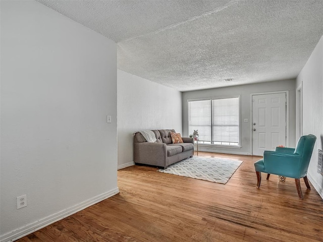 living room featuring a textured ceiling and light wood-type flooring