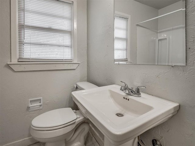 bathroom with sink, a shower, and toilet