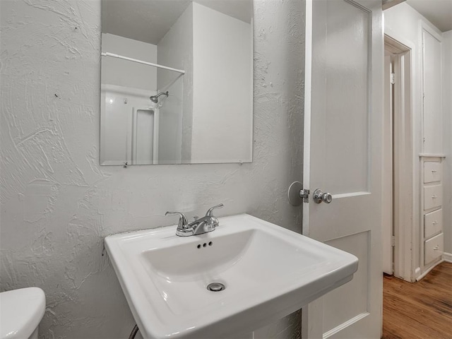 bathroom with sink, hardwood / wood-style floors, and toilet