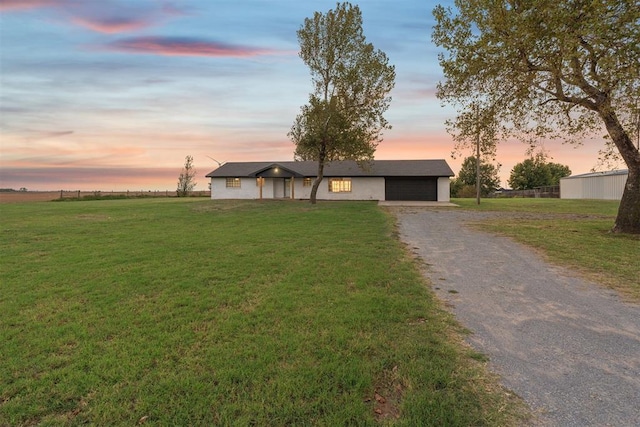 ranch-style home with a garage and a lawn