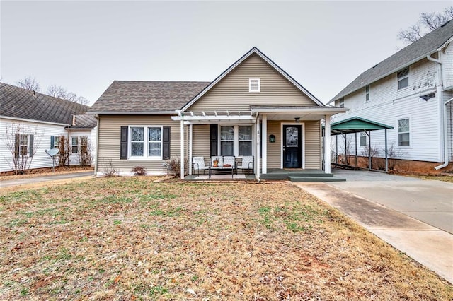 bungalow featuring a front lawn, a carport, and covered porch