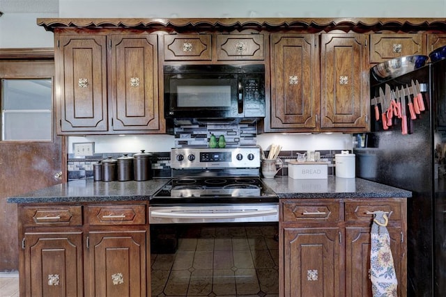 kitchen with dark stone counters, tile patterned flooring, and black appliances