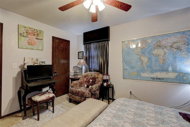 carpeted bedroom with ceiling fan and a textured ceiling