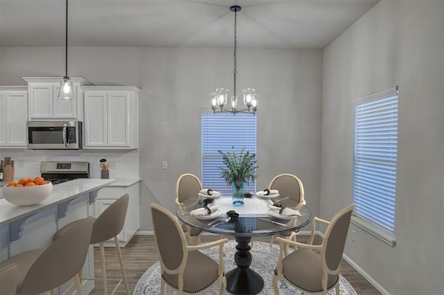 dining area with dark hardwood / wood-style flooring and an inviting chandelier