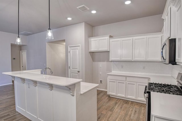 kitchen featuring white cabinetry, appliances with stainless steel finishes, and pendant lighting