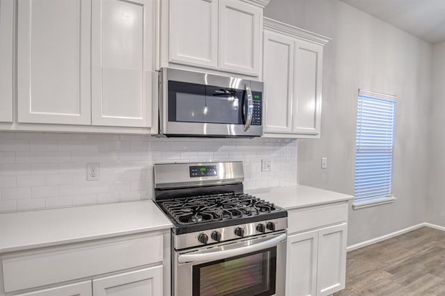 kitchen featuring white cabinetry, backsplash, stainless steel appliances, and light hardwood / wood-style floors