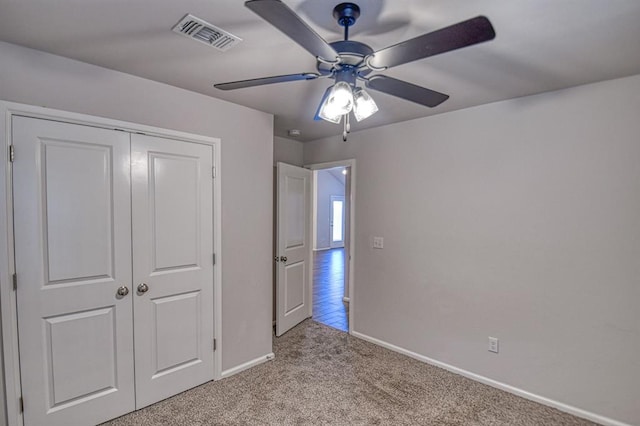 unfurnished bedroom with light colored carpet, a closet, and ceiling fan