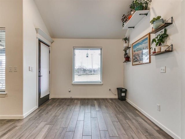 unfurnished room with light hardwood / wood-style flooring and vaulted ceiling