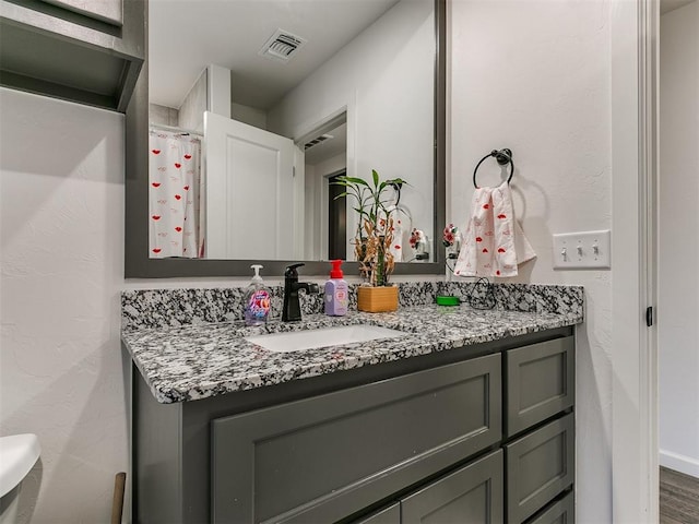 bathroom featuring vanity, hardwood / wood-style floors, and toilet