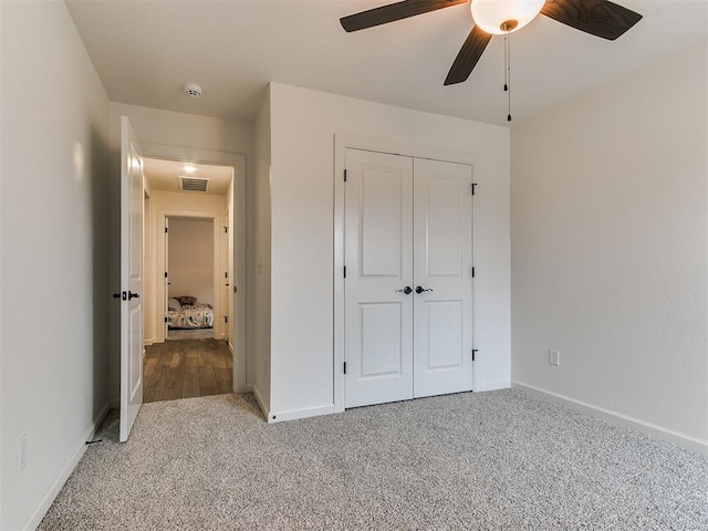 unfurnished bedroom with carpet flooring, ceiling fan, and a closet