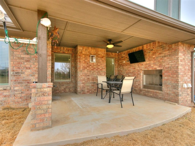 view of patio / terrace featuring an outdoor brick fireplace and ceiling fan