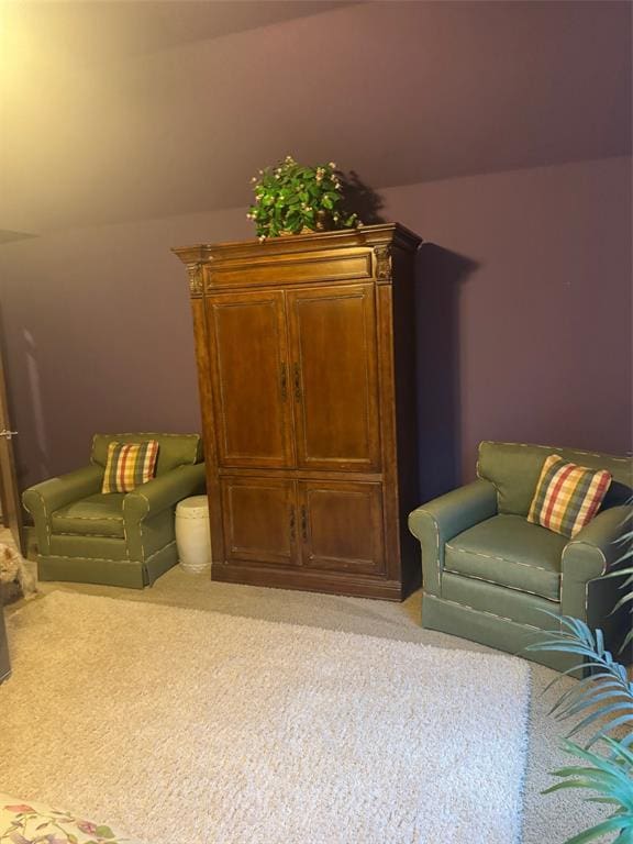 sitting room featuring vaulted ceiling and light carpet