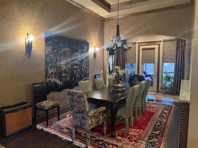 dining area with an inviting chandelier, ornamental molding, and dark hardwood / wood-style floors