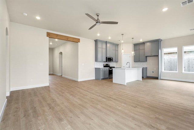 unfurnished living room with ceiling fan and light wood-type flooring