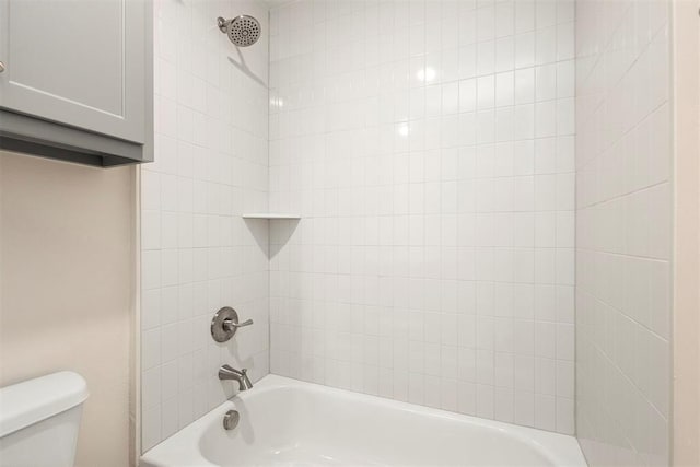 bathroom featuring toilet and tiled shower / bath combo