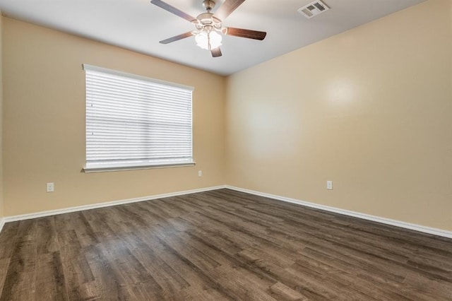 spare room featuring dark wood-type flooring and ceiling fan