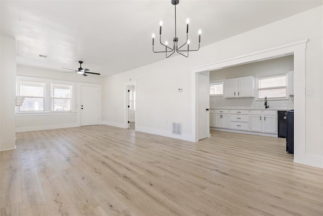 interior space with ceiling fan with notable chandelier and light hardwood / wood-style floors