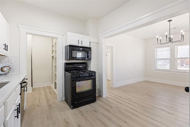 kitchen with light wood-type flooring, white cabinets, light stone counters, and black appliances