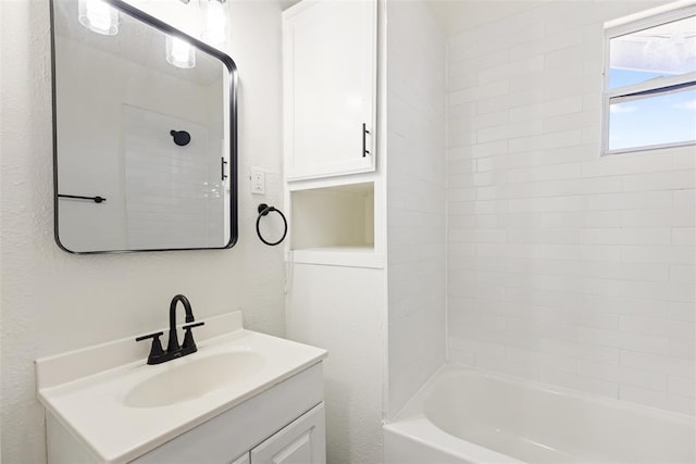 bathroom featuring tiled shower / bath combo and vanity