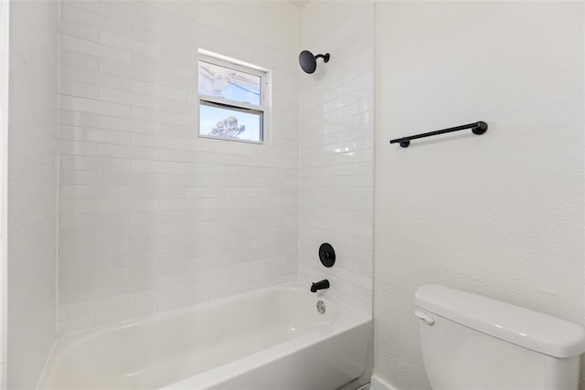 bathroom with tiled shower / bath combo and toilet