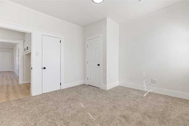 spare room featuring ornamental molding and light colored carpet