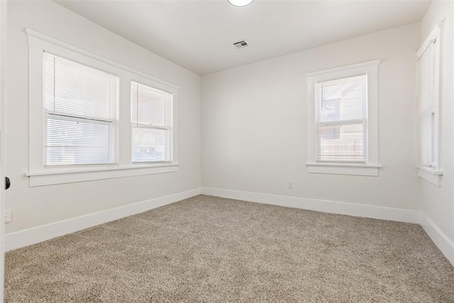 empty room with a healthy amount of sunlight and carpet