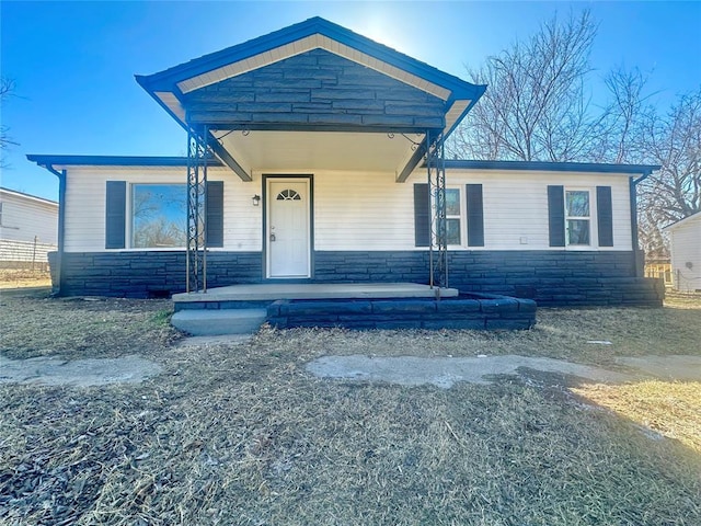 view of front of home featuring stone siding and a porch