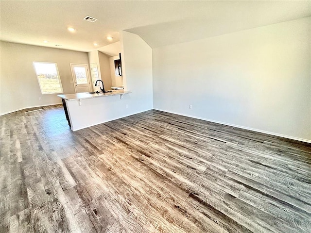 unfurnished living room with dark wood-type flooring and sink