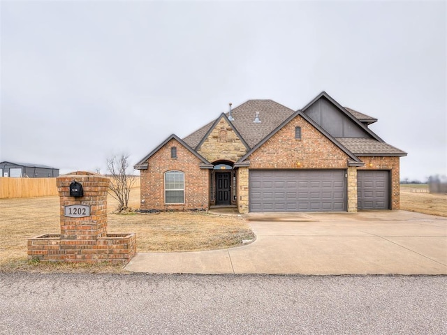 view of front of home with concrete driveway, brick siding, fence, and an attached garage