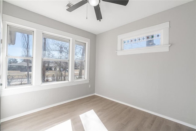 unfurnished room featuring ceiling fan, a healthy amount of sunlight, and light wood-type flooring