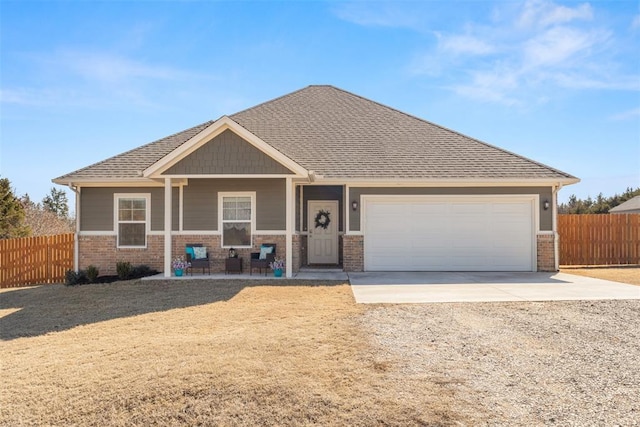 craftsman house with brick siding, driveway, an attached garage, and fence