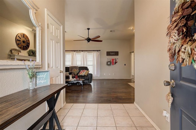 foyer entrance with light tile patterned floors and ceiling fan