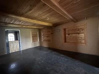 misc room featuring beam ceiling, wooden ceiling, and concrete floors